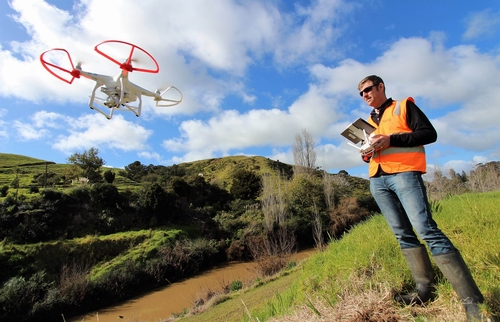 Man operating a drone to survey river works.