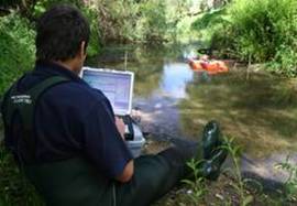 Using ADCP and laptop to measure water flow.