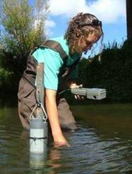 An NRC staff member taking water samples in a river.