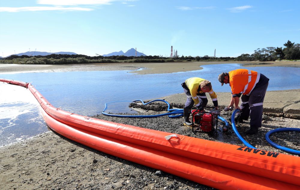 Two men with oil spill response equipment.