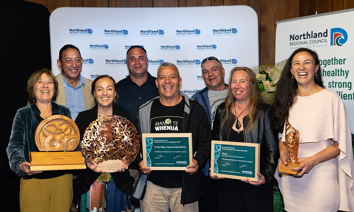 People holding trophies and certificates.