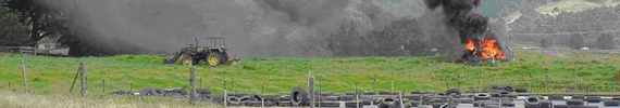 Black smoke from a puposely lit fire to dispose of rubbish on a farm.