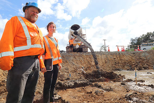 Two people in hi-vis at construction site.