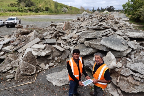 two regional council staff members standing in front of pile of broken concrete.