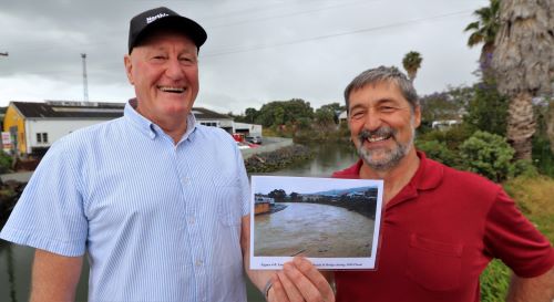 Jack Craw and Joe Camuso holding photo of river in flood.