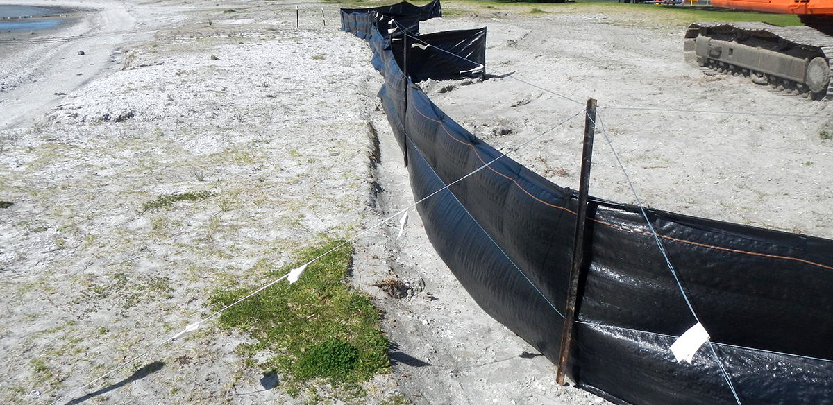 A black fabric fence on a beach.