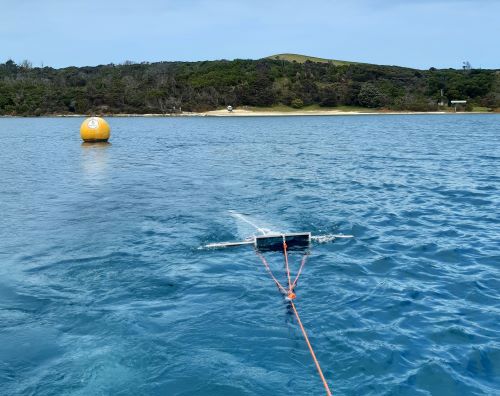 Plankton net being towed behind a boat across a lake.