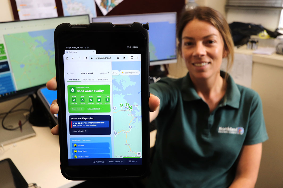 Woman showing Safeswim site displayed on a device.