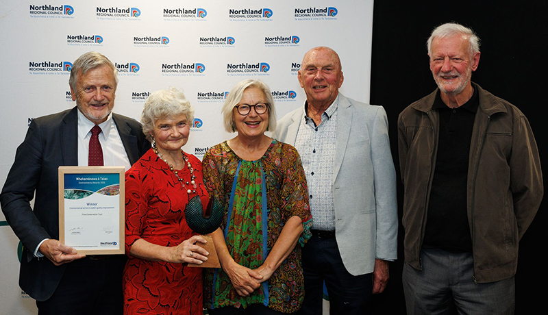 Two women and three men with trophy and certificate in front of Northland Regional Council logo backdrop. (Photo: Dawn Dutton Photography).