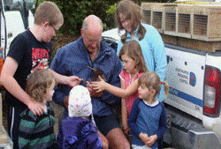 Description: Children looking at a Kiwi. 
