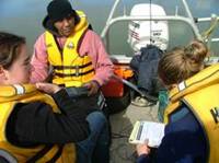 Volunteers in a boat carrying out water quality monitoring.