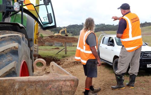 Two men by earth moving machinery.