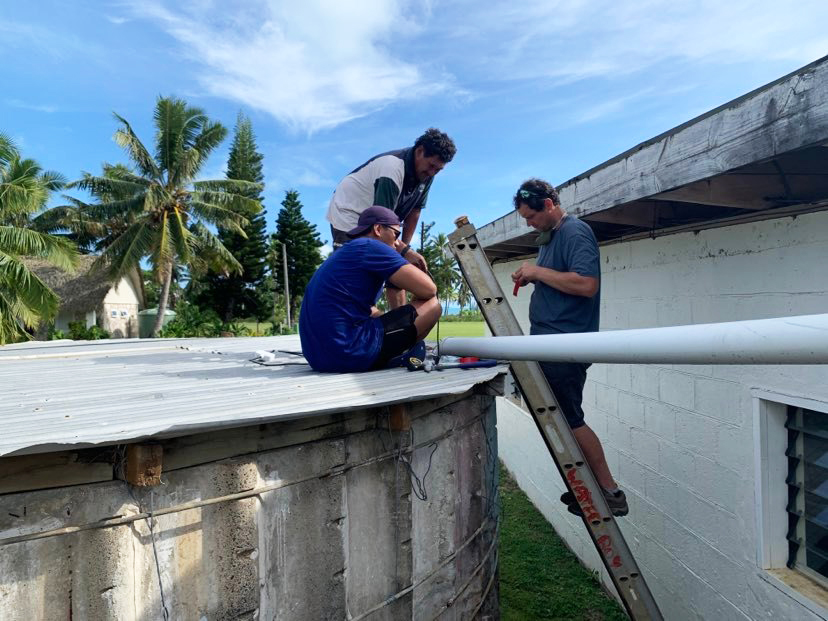 Men on water tank in the Cook Islands.