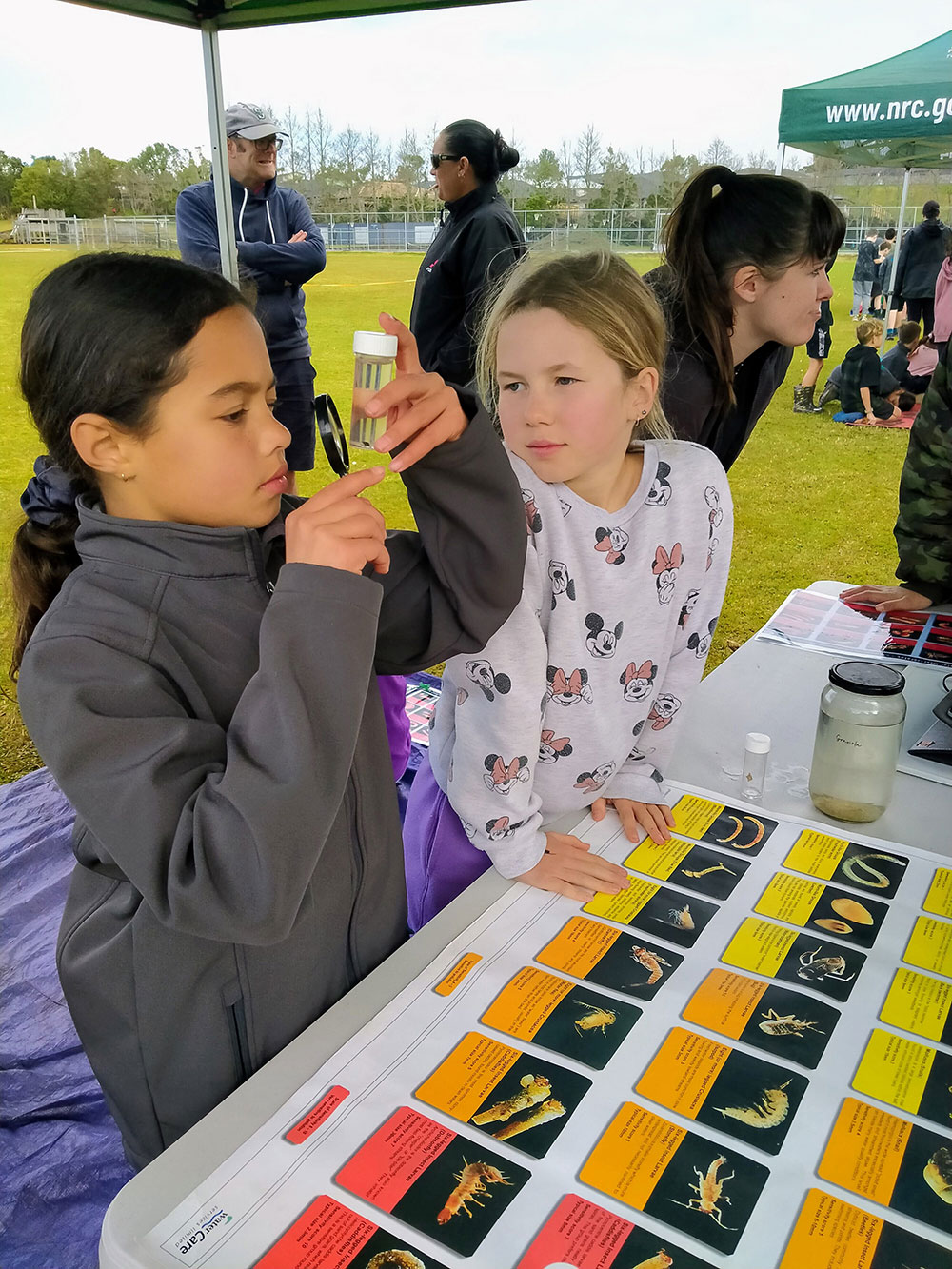 Girls looking at insect larvae.