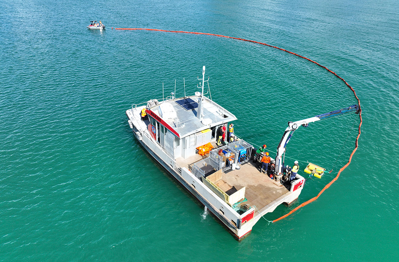 Aerial shot of two boats deploying a boom.