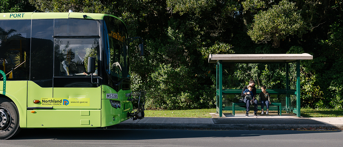 CityLink bus approaching a bus stop with passengers waiting.