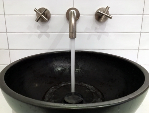 A tap running water into a basin.