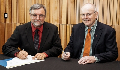 Malcolm Nicolson and Bill Shepherd sign the agreement.