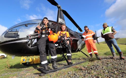 Deer operation team in front of helicopter.