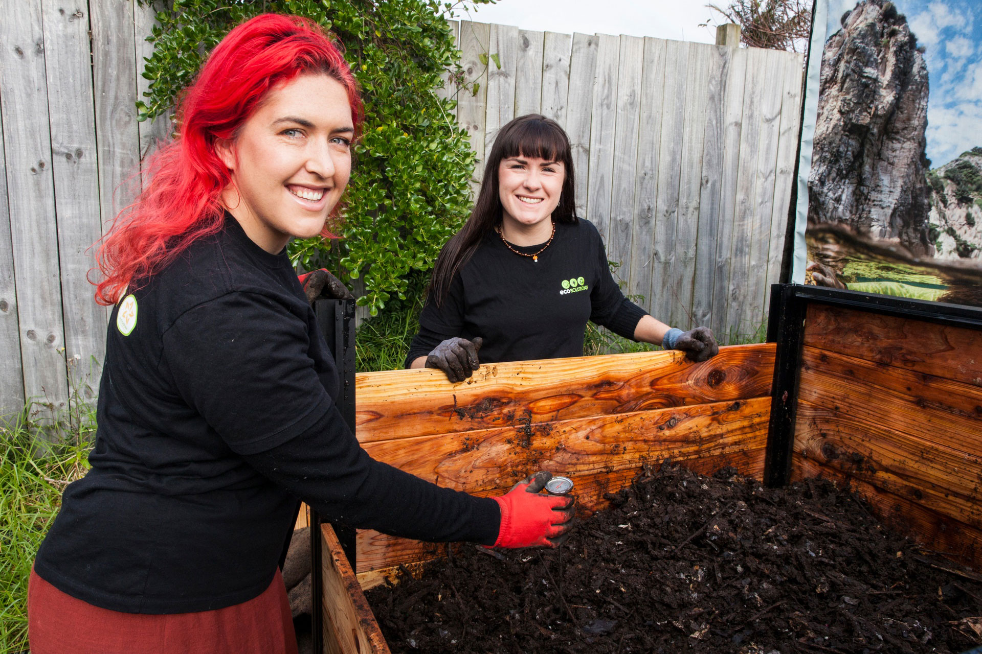 Two woman show the compost bin. (Image Wendy Bown)