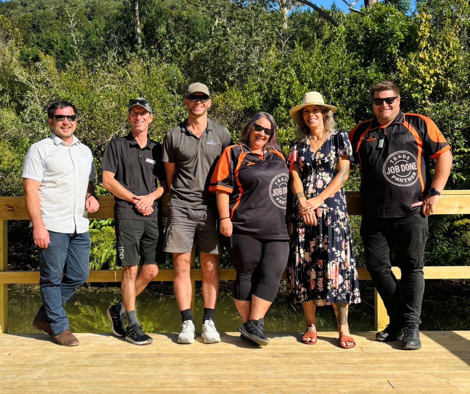 Six people men and women, stand on a jetty at the wetland.
