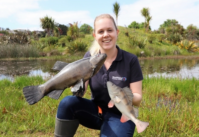 Brooke Hartigan holding fibreglass mounts of a tench and a perch.