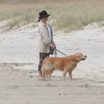 Person on the beach with a dog.