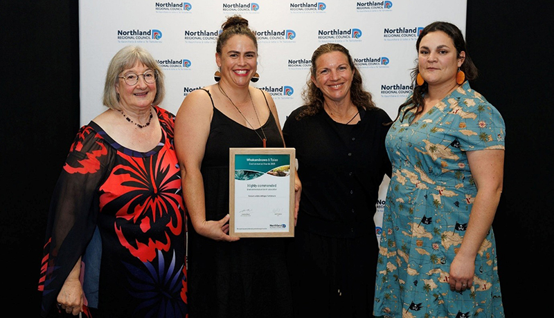 Four women with certificate in front of Northland Regional Council logo backdrop. (Photo: Dawn Dutton Photography).