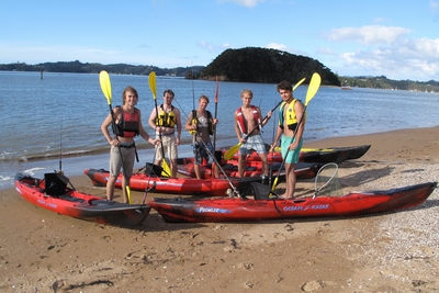 Kayaks and people on beach.