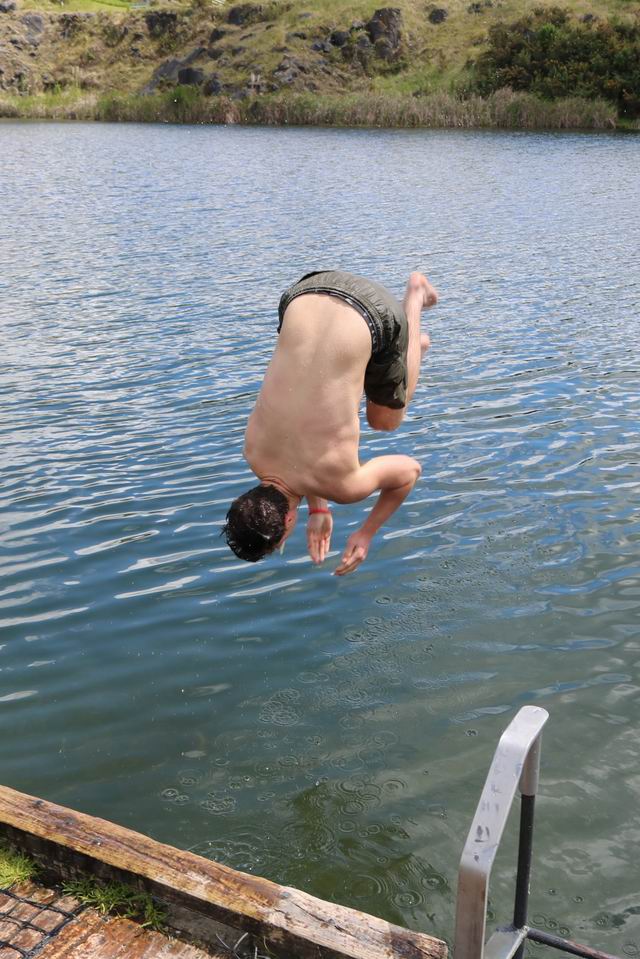 Boy doing a flip into the water.