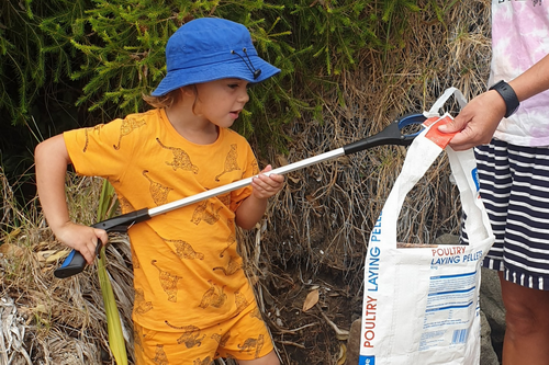 Child picking up rubbish.