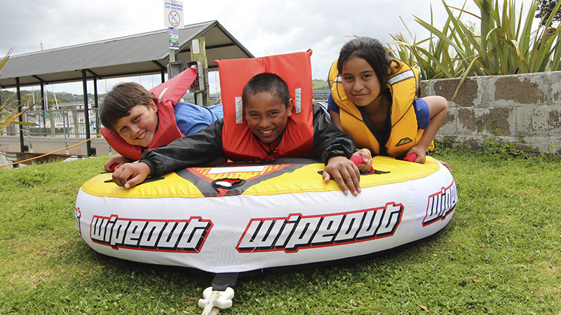 Three young people on a sea biscuit on land.