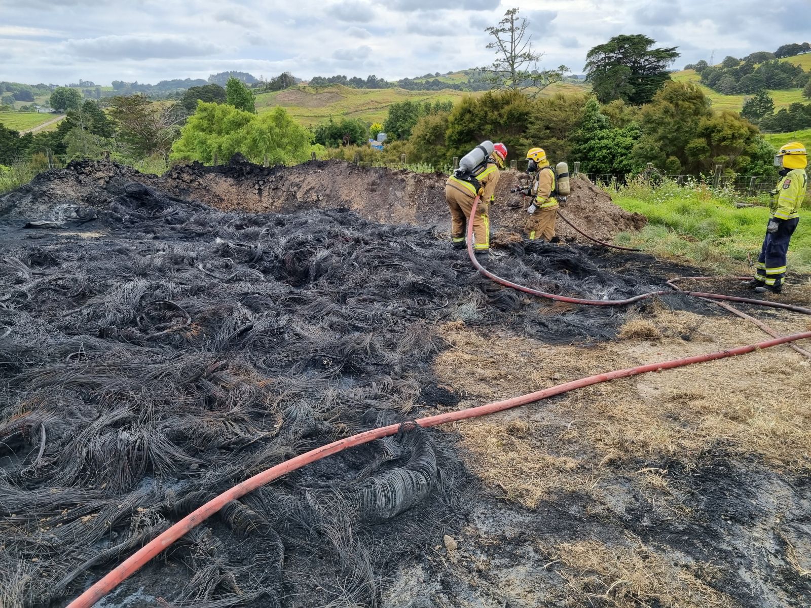 Fire fighters extinguishing the remains of a tyre burning.