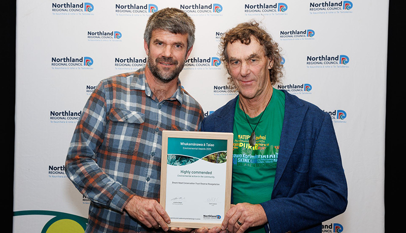 Two men with certificate in front of Northland Regional Council logo backdrop. (Photo: Dawn Dutton Photography).