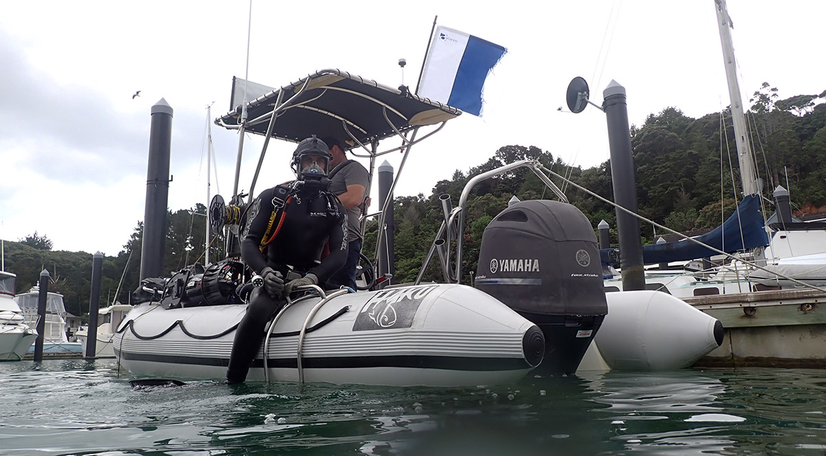 Man in SCUBA gear on inflatable boat.