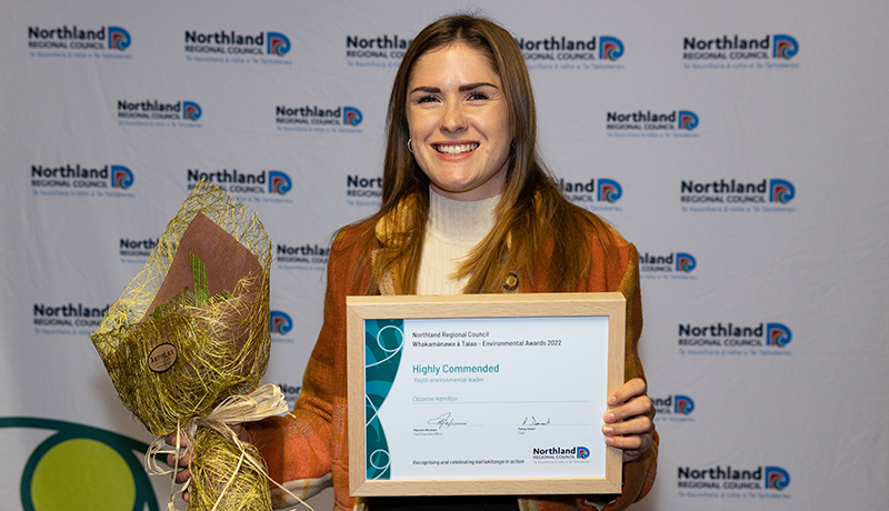 Woman with flowers and certificate.