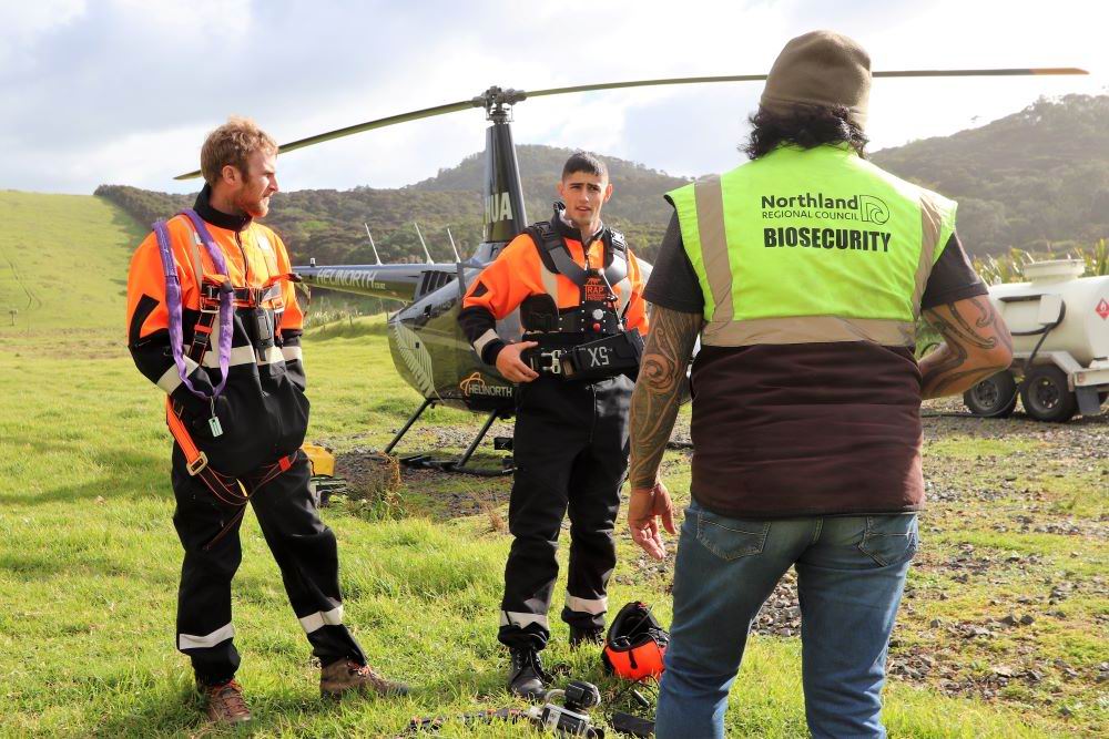 Men standing in front of a helicopter.