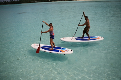 Two people standing on paddleboards.