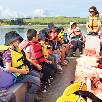 Children wearing lifejackets on a boat.