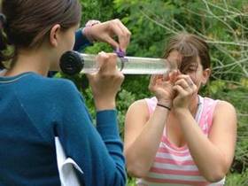 Students learning how to test water clarity using a clarity tube.