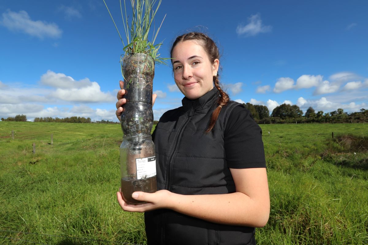 Participant Manaia Butler holds a potted wetland plant – simulating how wetlands filter dirt and contaminants.