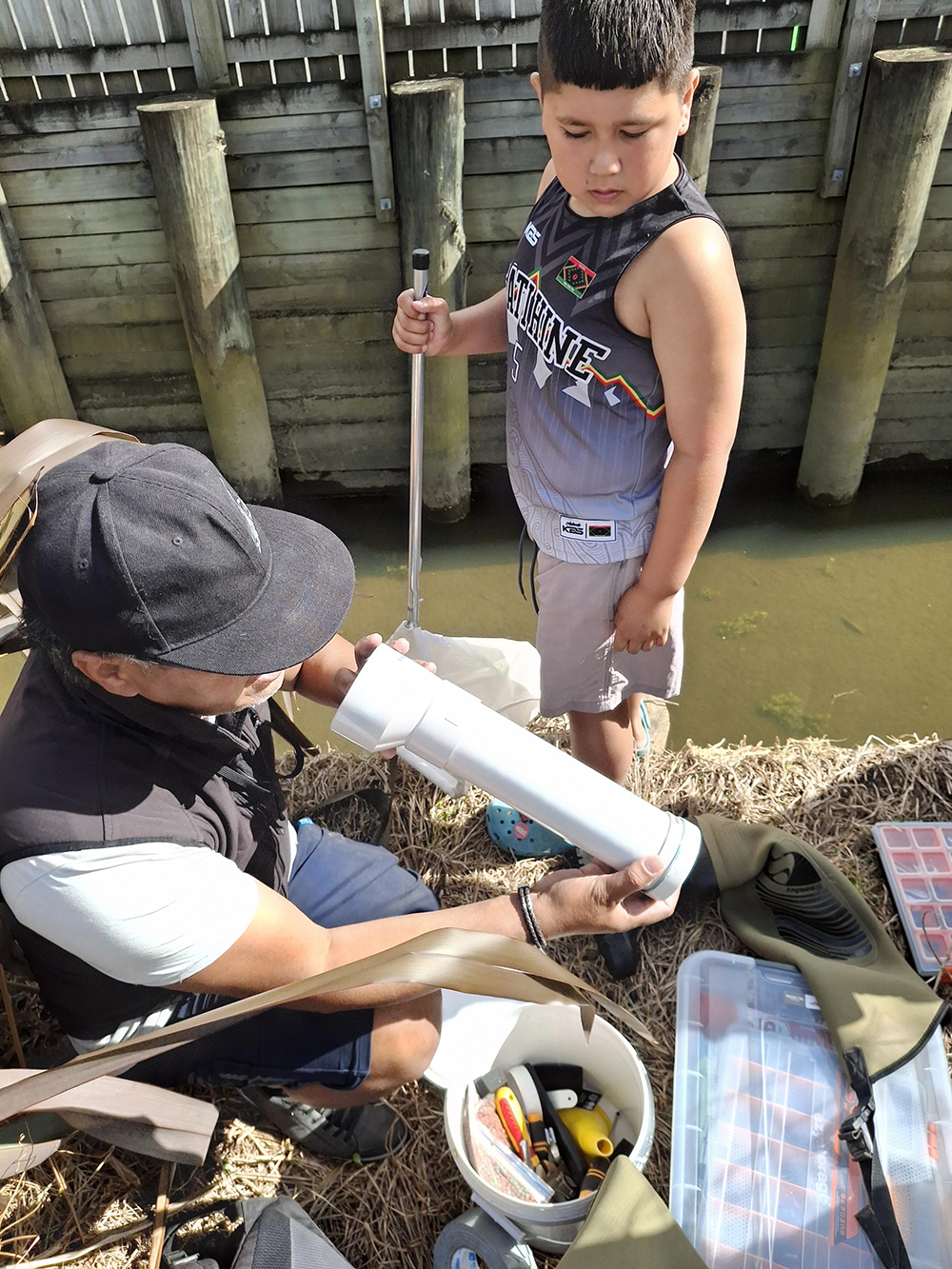 Boy watches a man set up equipment to monitor the awa.