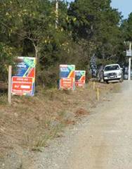 House sale signs on roadside.