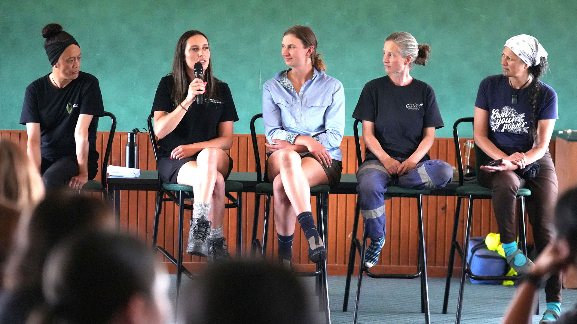 Five women in a row on a stage.