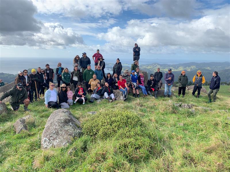 Attendees stand on the top of the Maunga Huruiki for the Waimā Waitai Waiora hui.