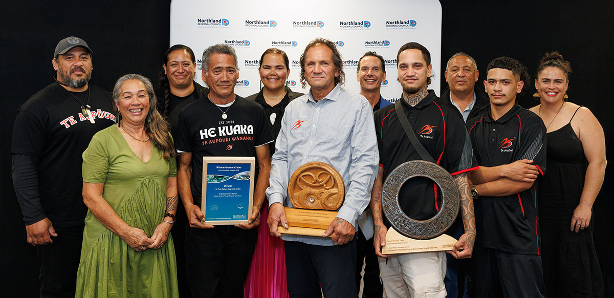 Group of 11 people with a certificate and two trophies.
