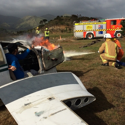 Fireman and young person putting out an aircraft fire.