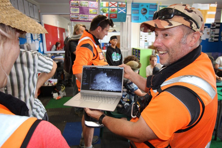 Predator Free Biosecurity officer with footage of a juvenile possum hitching a ride with mum