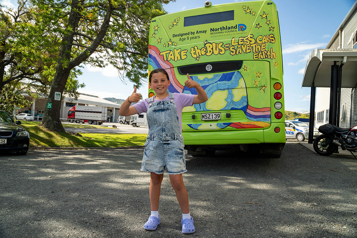 Girl in front of bus back.