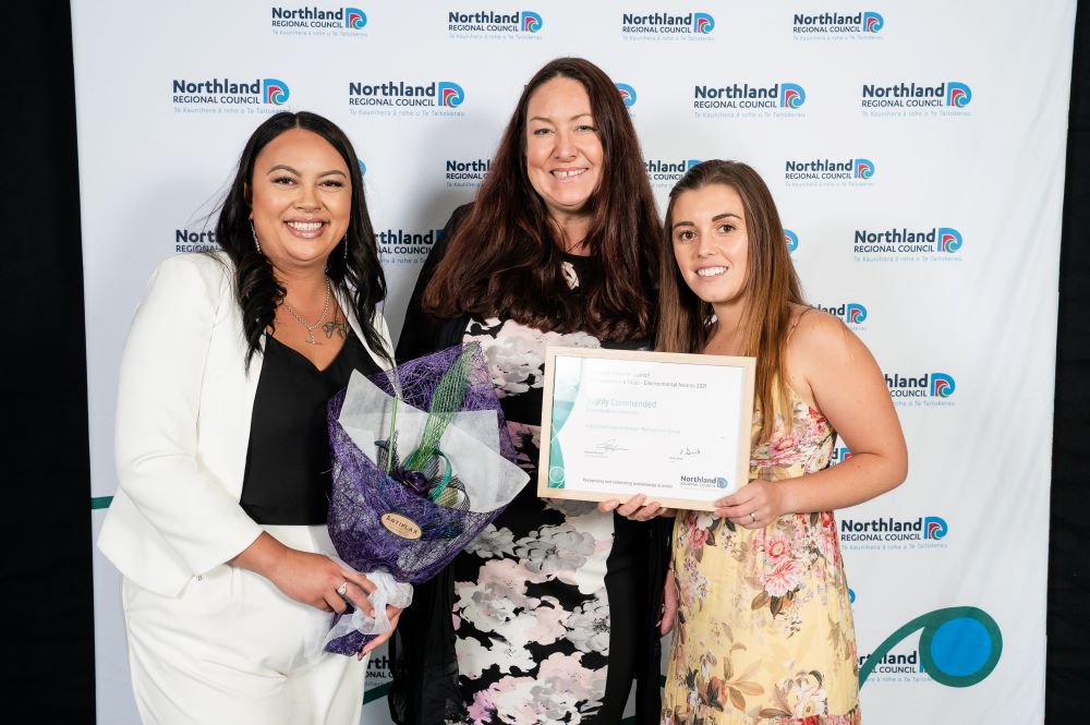 Three women with award.